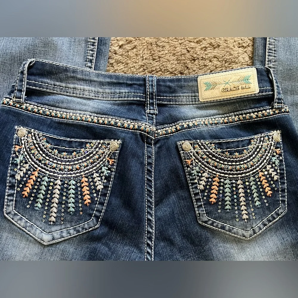 Grace in LA bootcut blue jeans with sequin and embroidery designs. Women’s 29